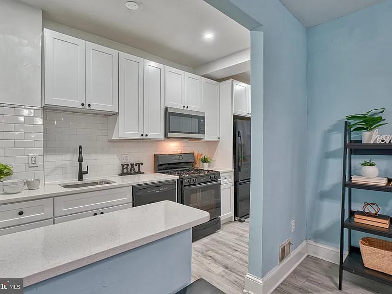 Kitchen with custom cabinets, a gas range and tile backsplash